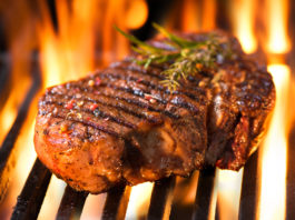 Steak auf einem Grillrost über Feuer
