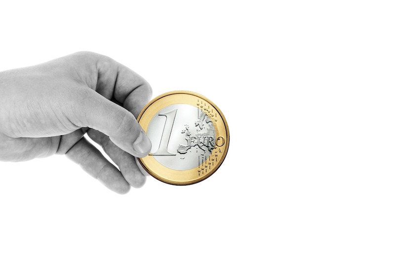 Euromüns in einer Hand vor weißem Hintergrund